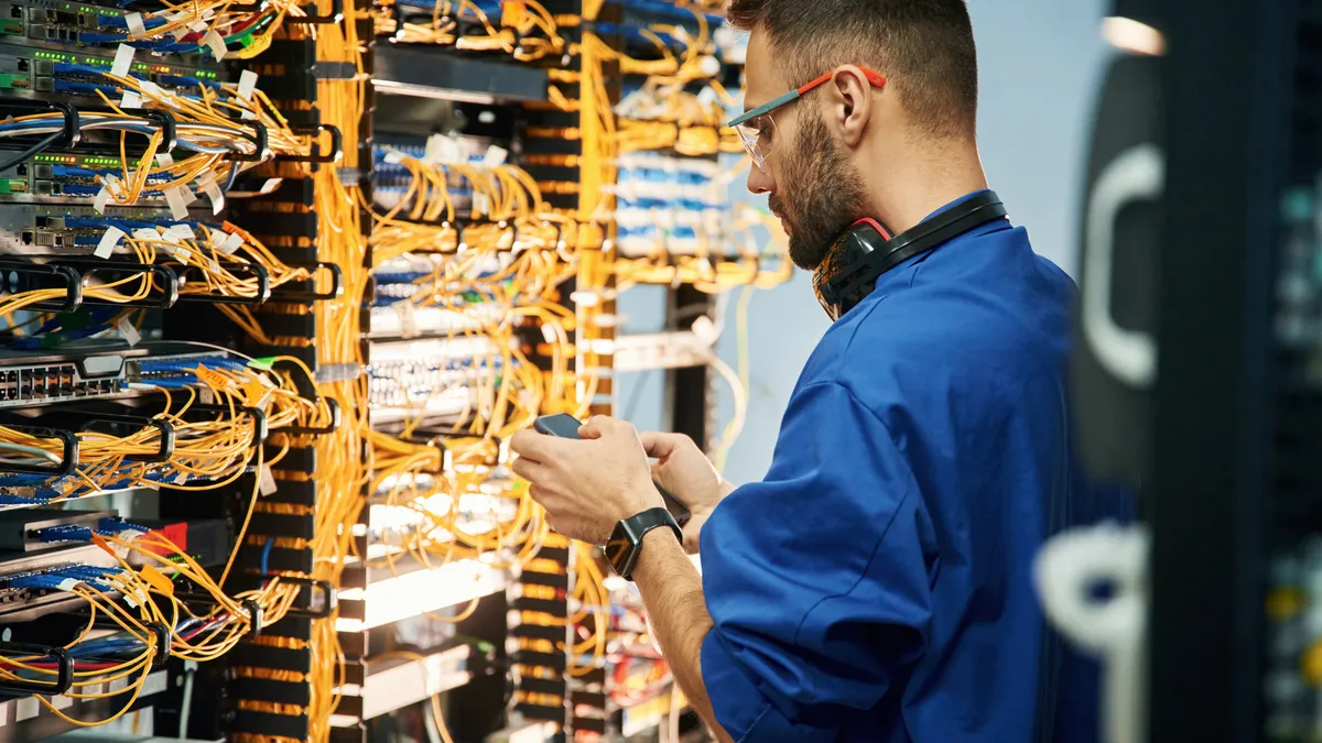 a technician reviews IT equipment in an IT room