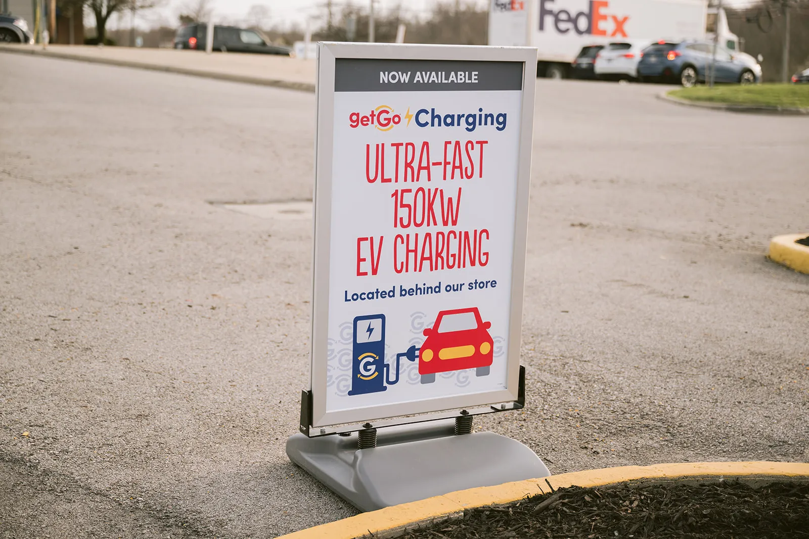 A photo of a sign at the grand opening of the first GetGo Energy EV charging location.