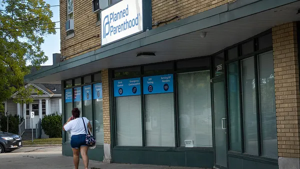 A pedestrian walks past a building with a "Planned Parenthood" sign on its facade