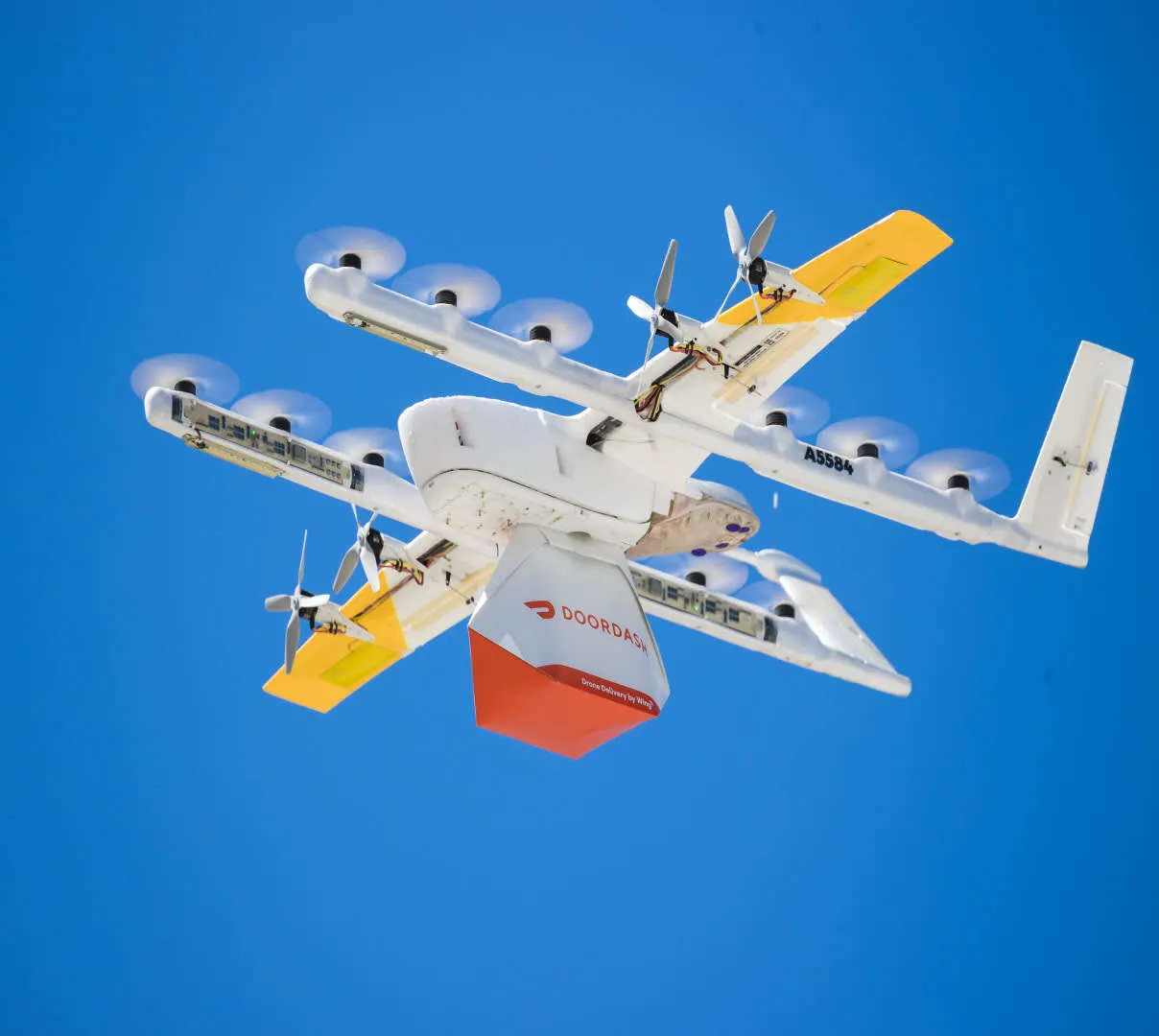 A Wing drone used by DoorDash delivers a Wendy's package.