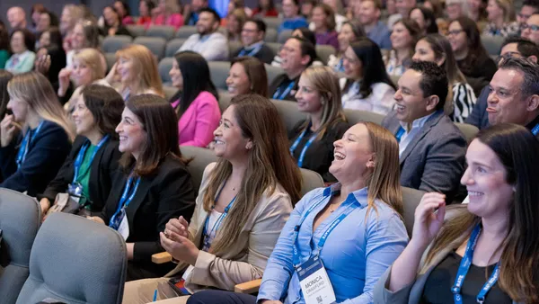 People in an auditorium smiling and laughing.