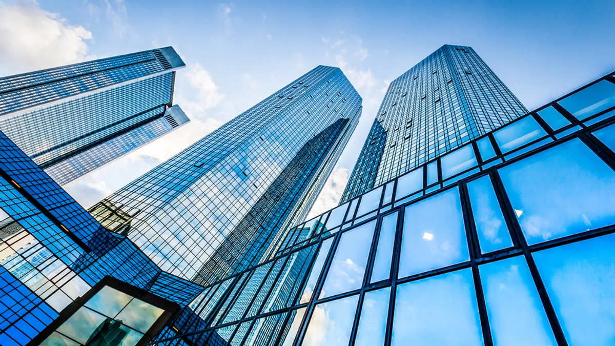 Bottom view of modern skyscrapers in business district against blue sky.