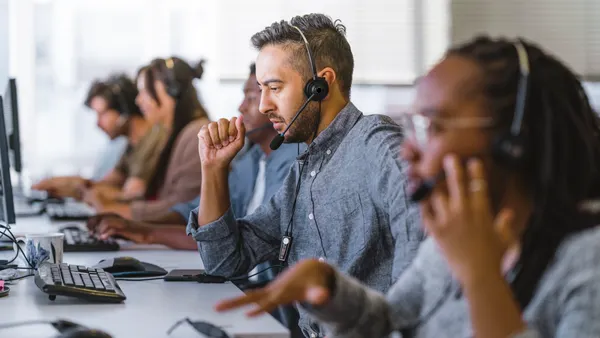 Contact center agents work in a row at call center.