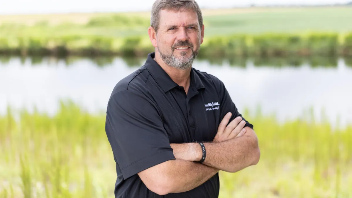 Kraig Westerbeek, Smithfield's newly appointed president of hog production, stands with his arms crossed wearing a black shirt.