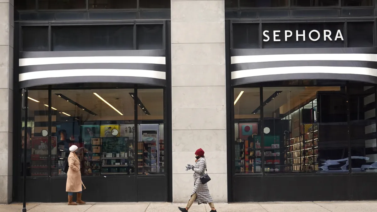 People walk by a Sephora storefront.