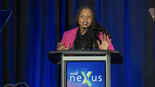 A person stands behind a podium and speaks.