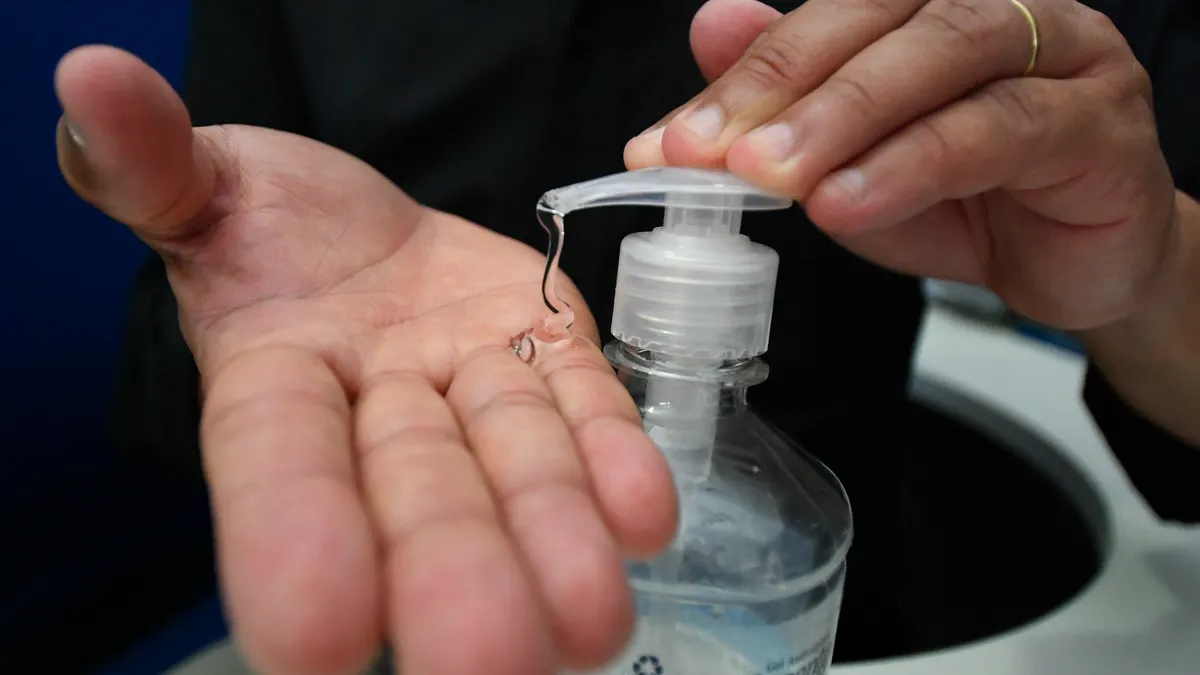 Close up shot of hands squeezing hand sanitizer