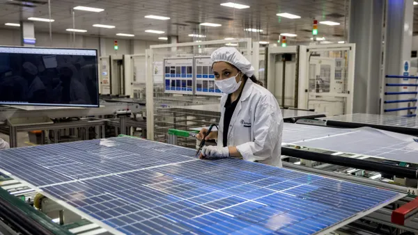 An employee works at a ingot-to-module solar factory