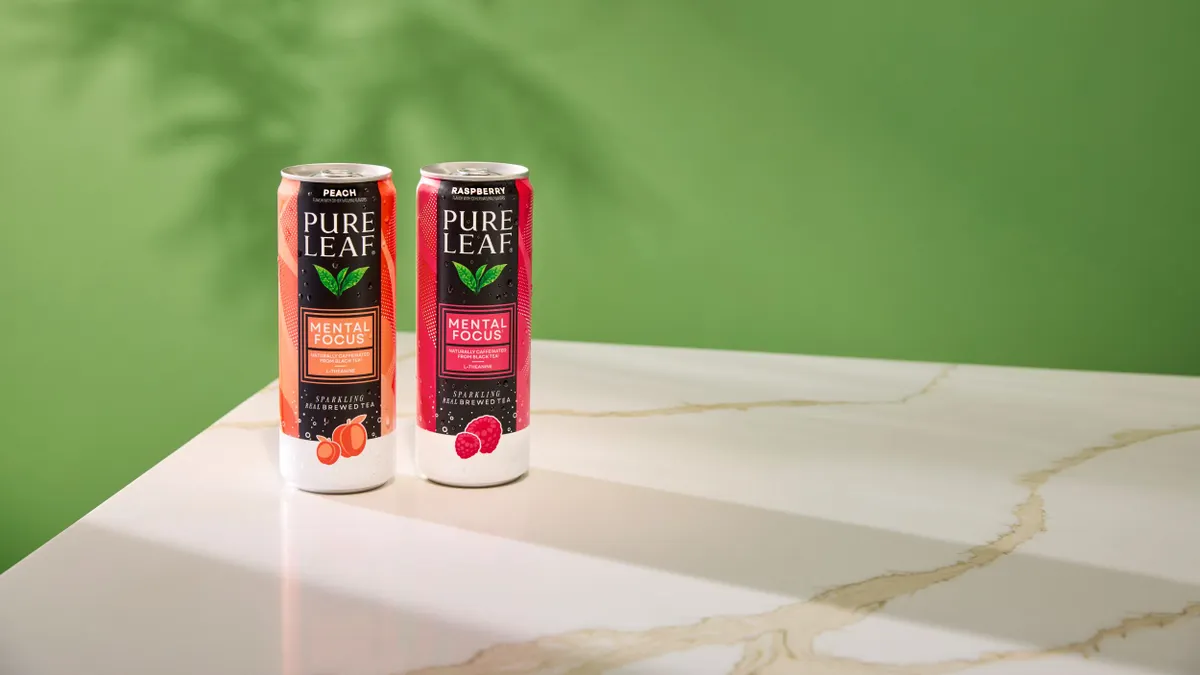 Two cans of Pure Leaf Mental Focus sit on a marble counter top.