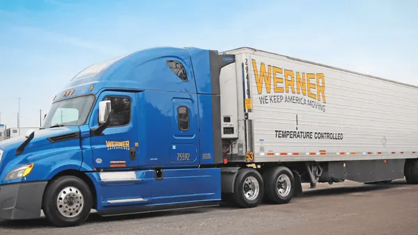 A blue freight truck parked on a road.