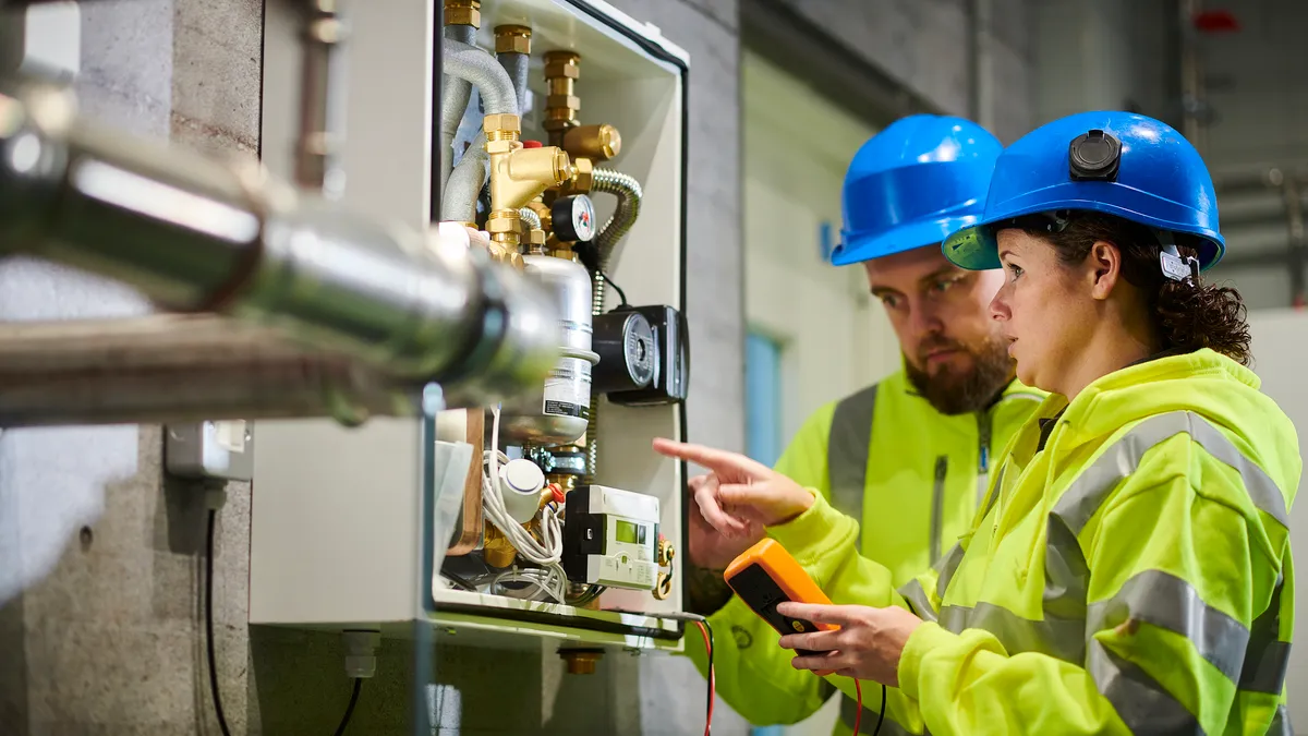 A technician trains another on a boiler.