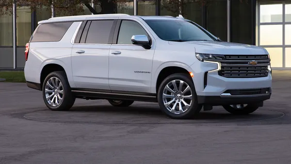A white 2021 Chevy Suburban SUV with chrome wheels SUV parked outdoors.