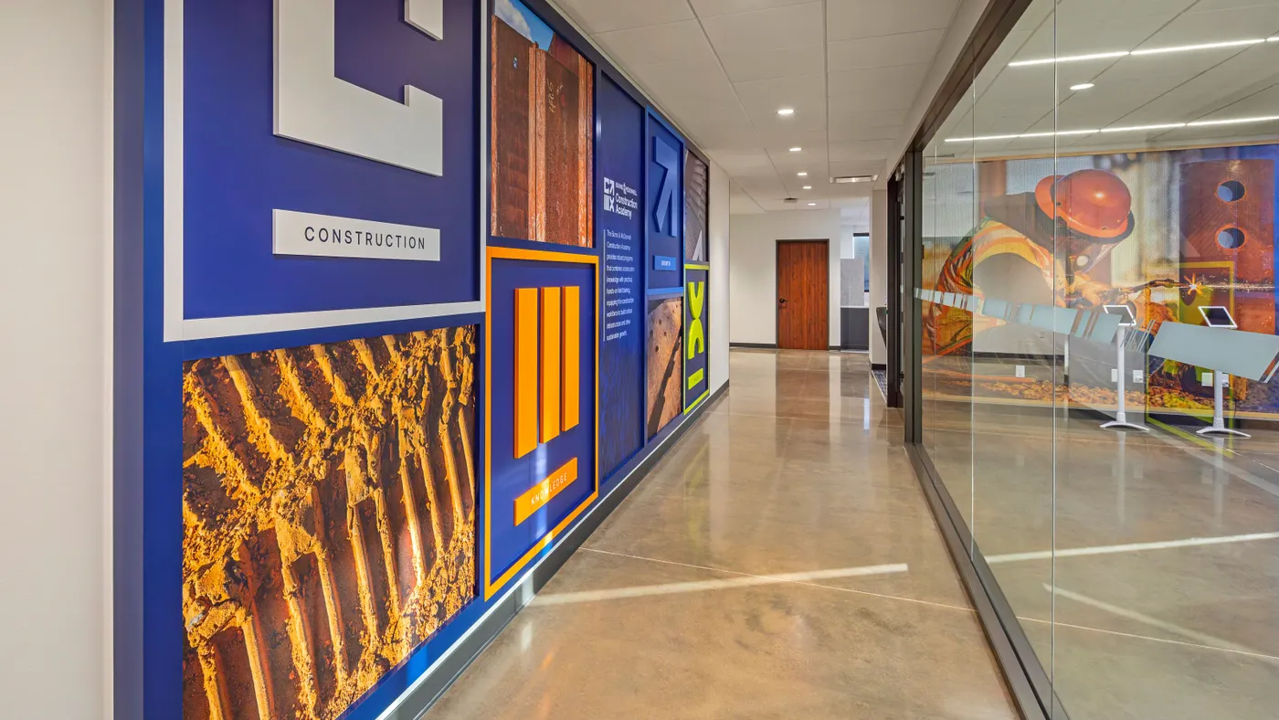 The interior of a building hallway with a colorful wall and glass office doors.