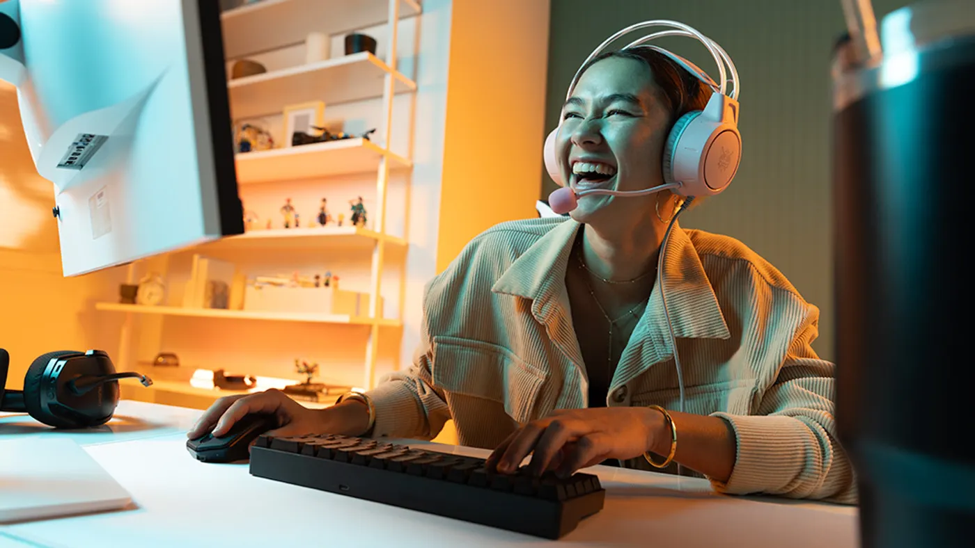 Person laughing at computer monitor