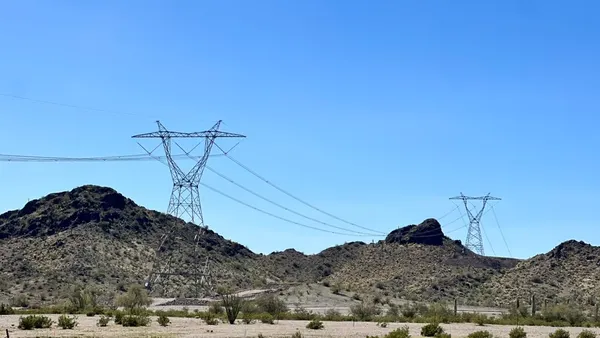 Electric transmission lines run through a desert.