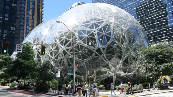 People walk in front of an art sculpture near the Amazon head office in Seattle.