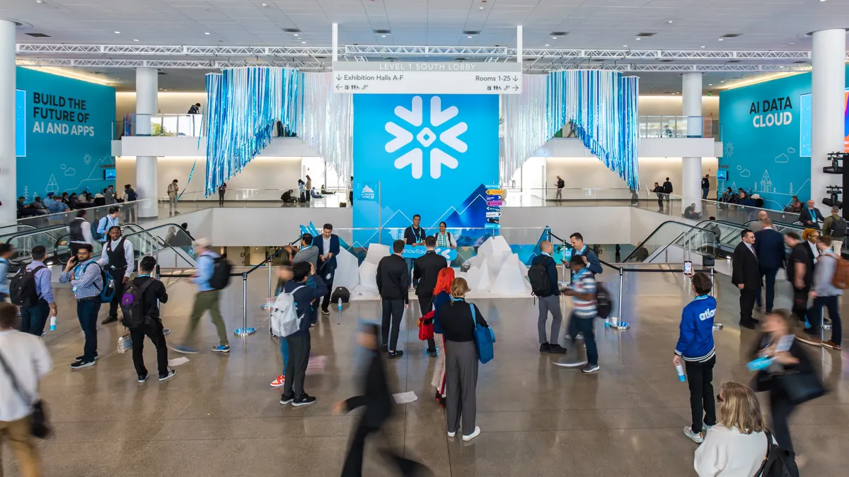 Attendees at the Snowflake Summit 2025 conference walk through a lobby of the Marcone Center in San Francisco on June 3, 2025.