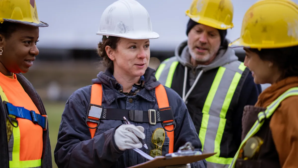 A woman construction worker talks to her team on the jobsite