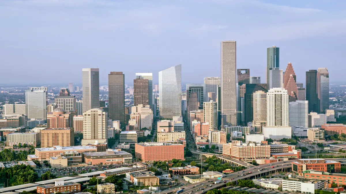 Aerial view of skyscrapers in downtown Houston against cloudy sky