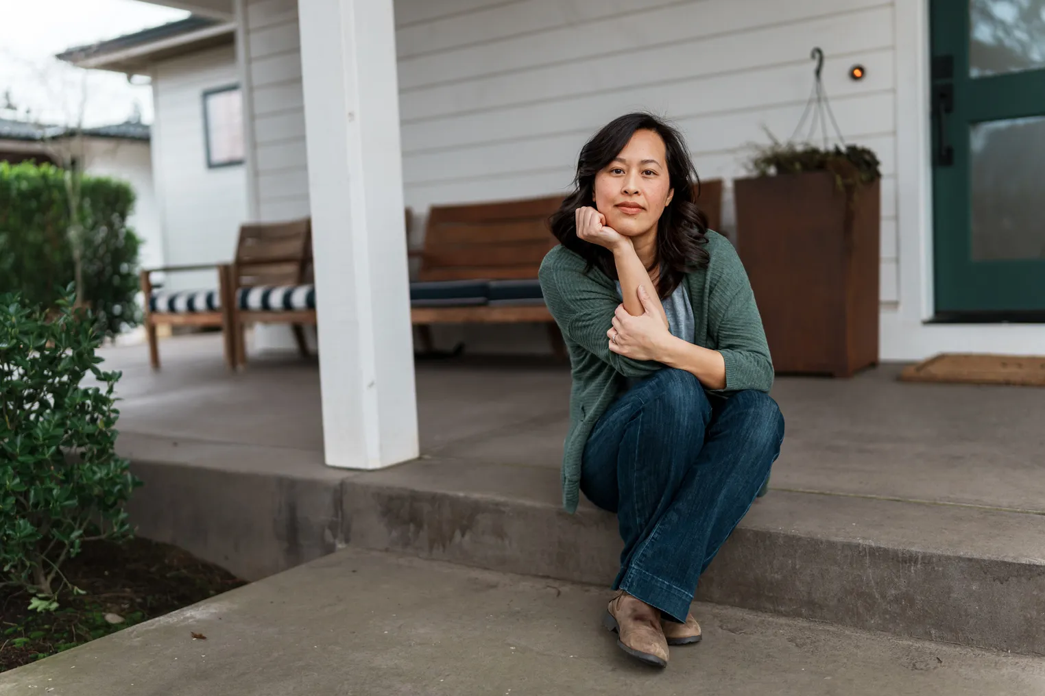 A Vietnamese person sits on front step of their home