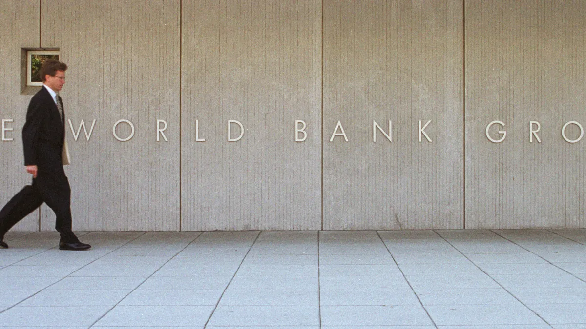 A man passes by the sign of the World Bank Group.