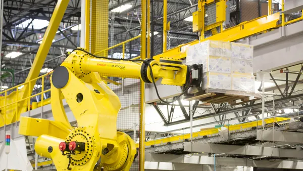 A robotic arm lifts a pallet of merchandise inside an Amazon Fulfillment Center on Feb. 13, 2015 in DuPont, Washington.