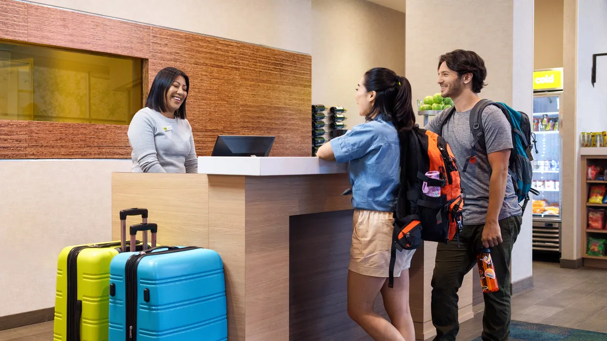 Hotel staff speak with guests at front desk