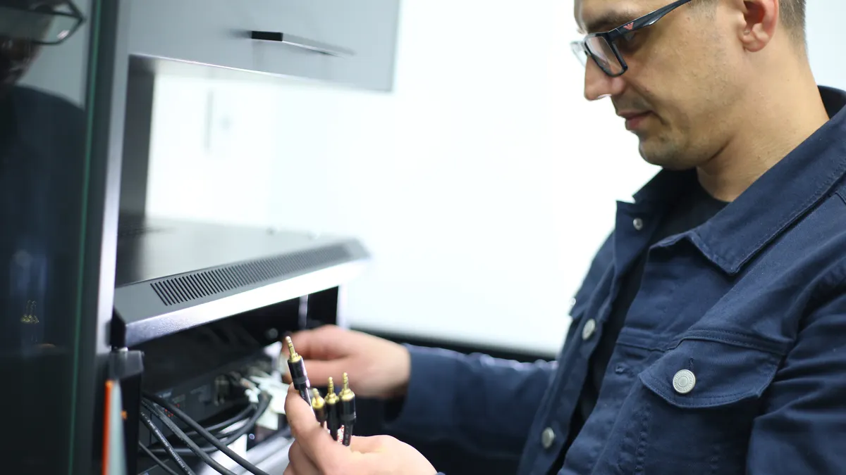 A technician connects audio cables.