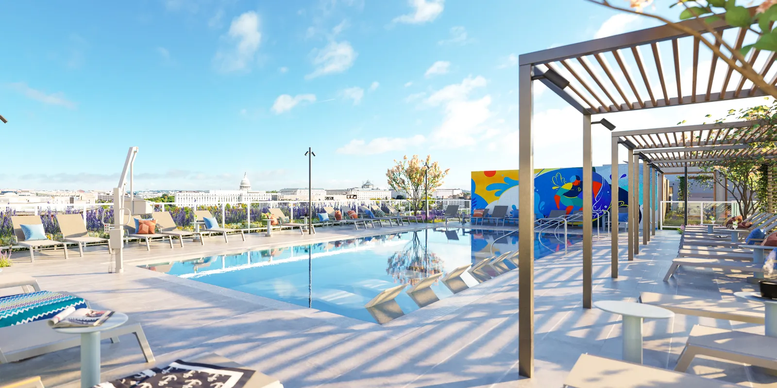 A rooftop pool with a mural located next to it.