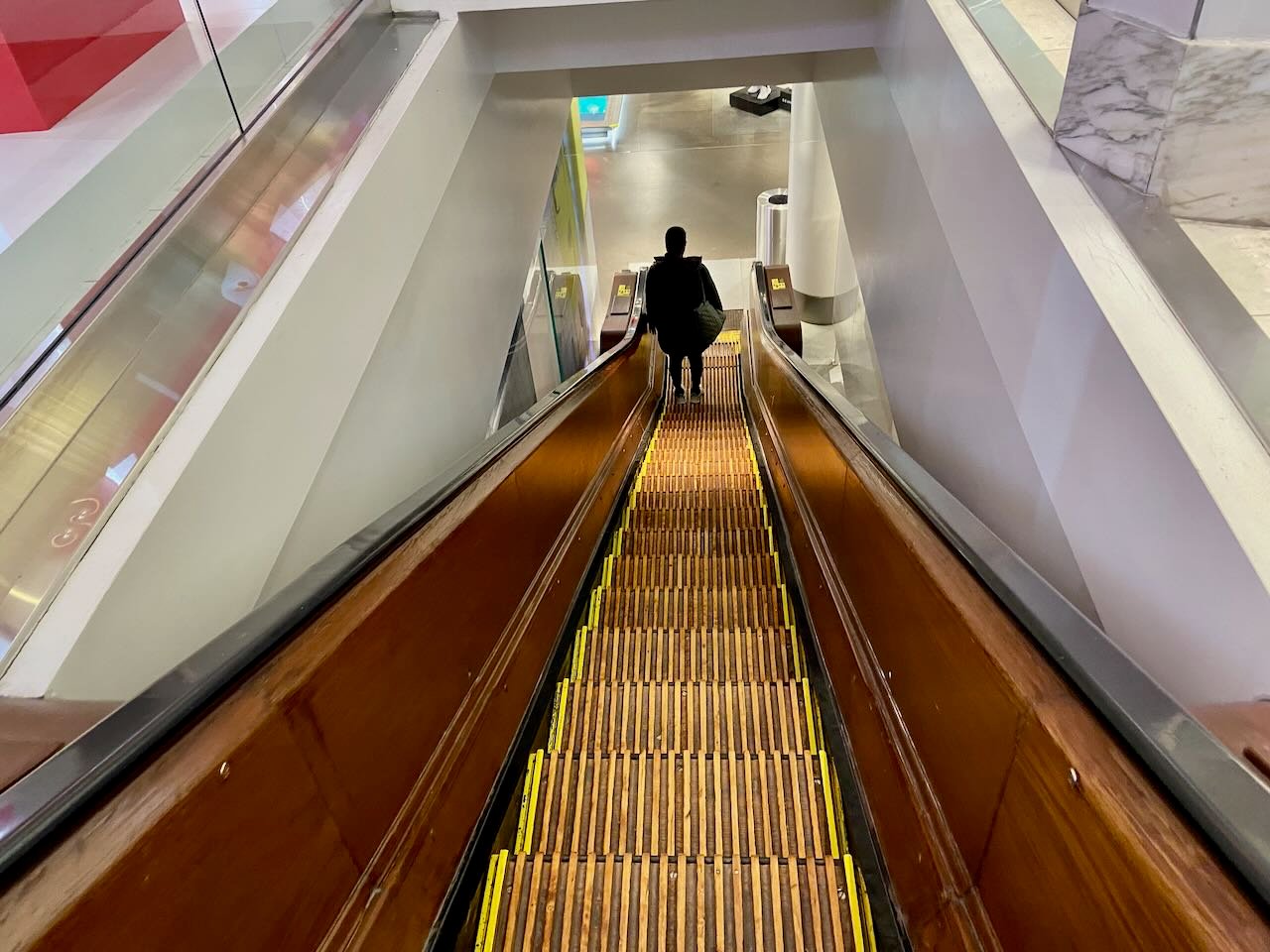 A person rides a wooden escalator