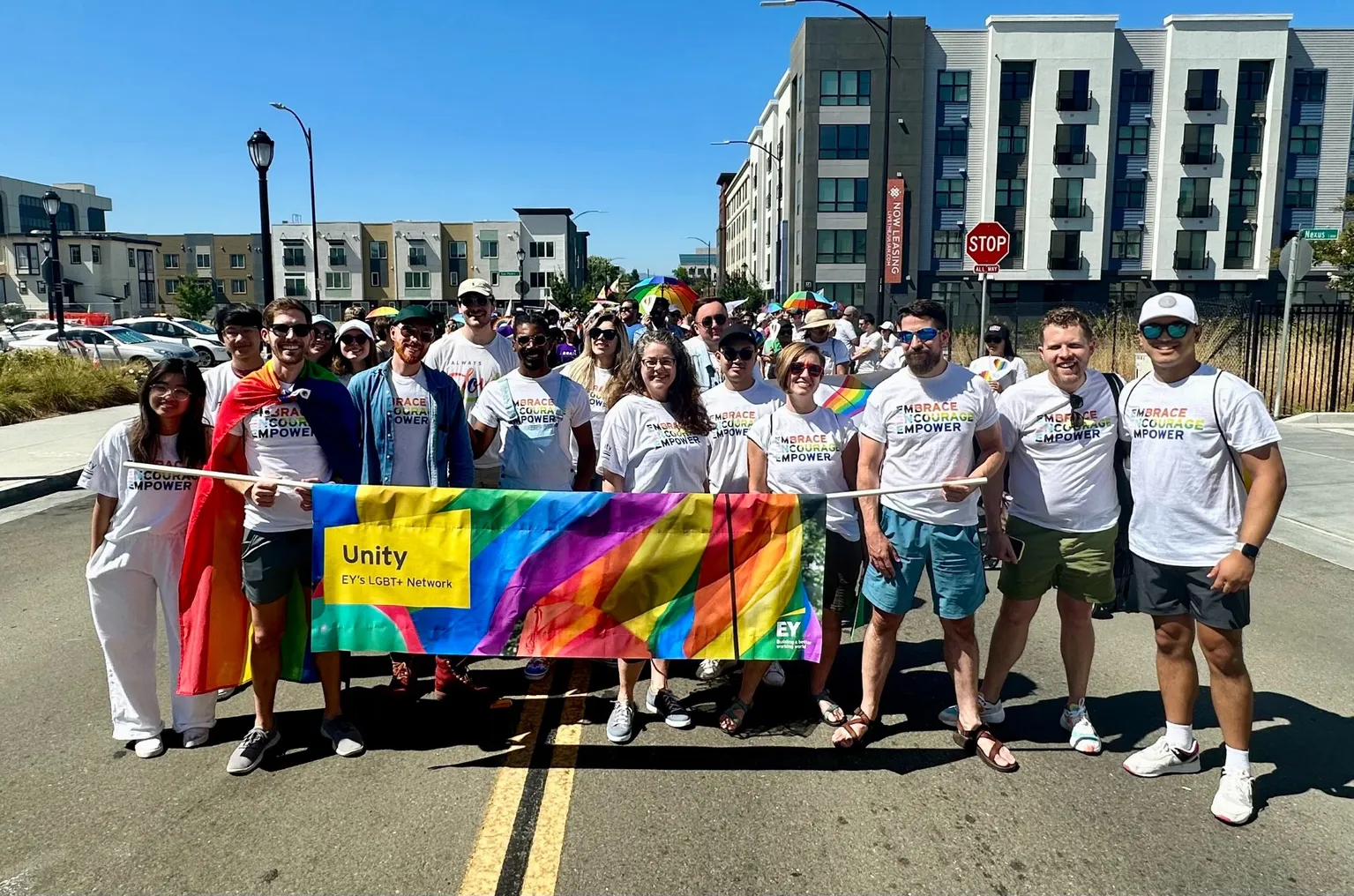 EY representatives carry a banner in a pride parade.