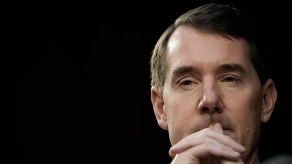 PNC CEO Bill Demchak holds his hands to his face while looking downward.