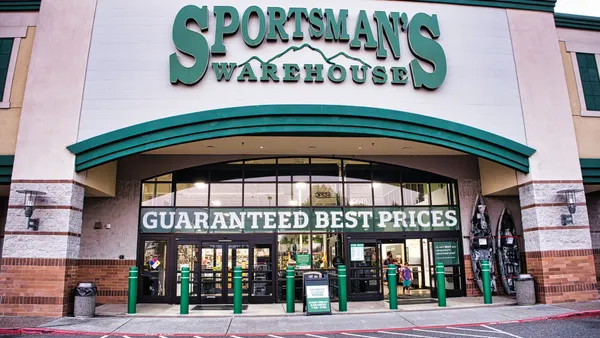A storefront with a sign "Sportsman's Warehouse" in green trim with windows.