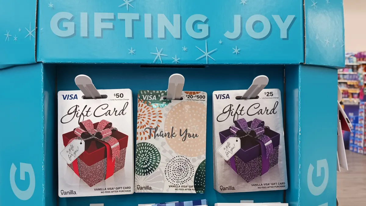 Gift cards hang on a rack in a store.