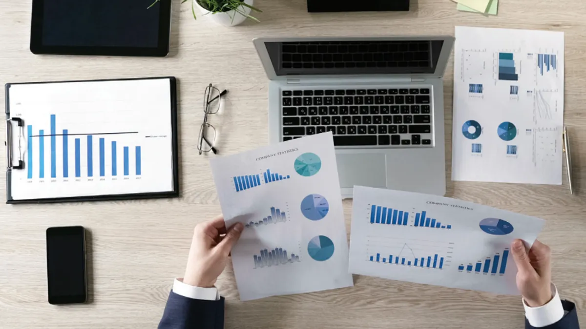 Man looking at paperwork with graphs at desk