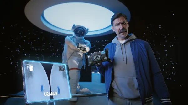Man holds Dude Wipes in a space-themed museum exhibit