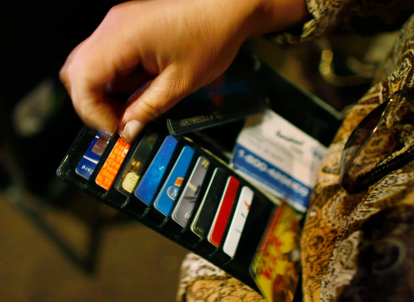 A person displays their open wallet and cards