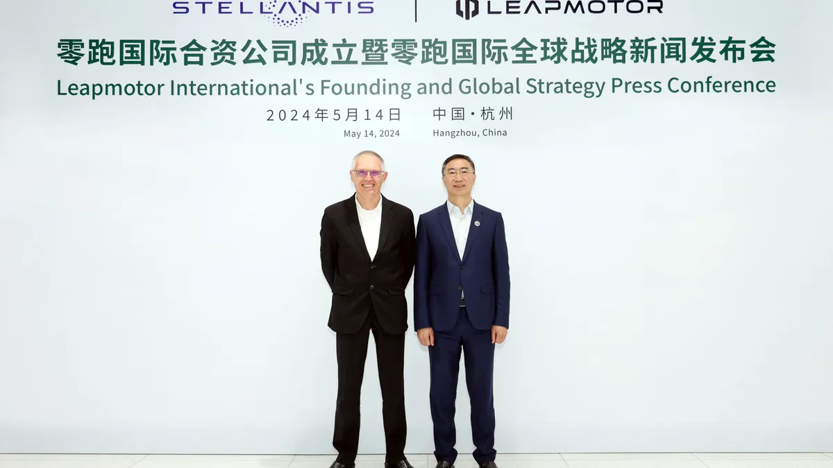 Stellantis CEO Carlos Tavares and Leapmotor CEO Jiangming Zhu pose for a photo on stage at a press conference in China announcing the launch of the new joint venture..