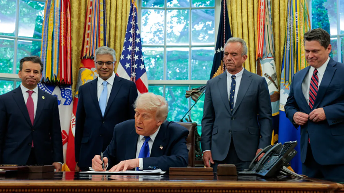 U.S. President Donald Trump, accompanied by Food and Drug Administration Commissioner Marty Makary (L), National Institutes of Health Director Jayanta Bhattacharya (2nd-L), Health and Human Services Secretary Robert F. Kennedy Jr. (2nd-R) and Domestic Policy Council Director Vince Haley (R), signs an executive order in the Oval Office at the White House on May 05, 2025 in Washington, DC