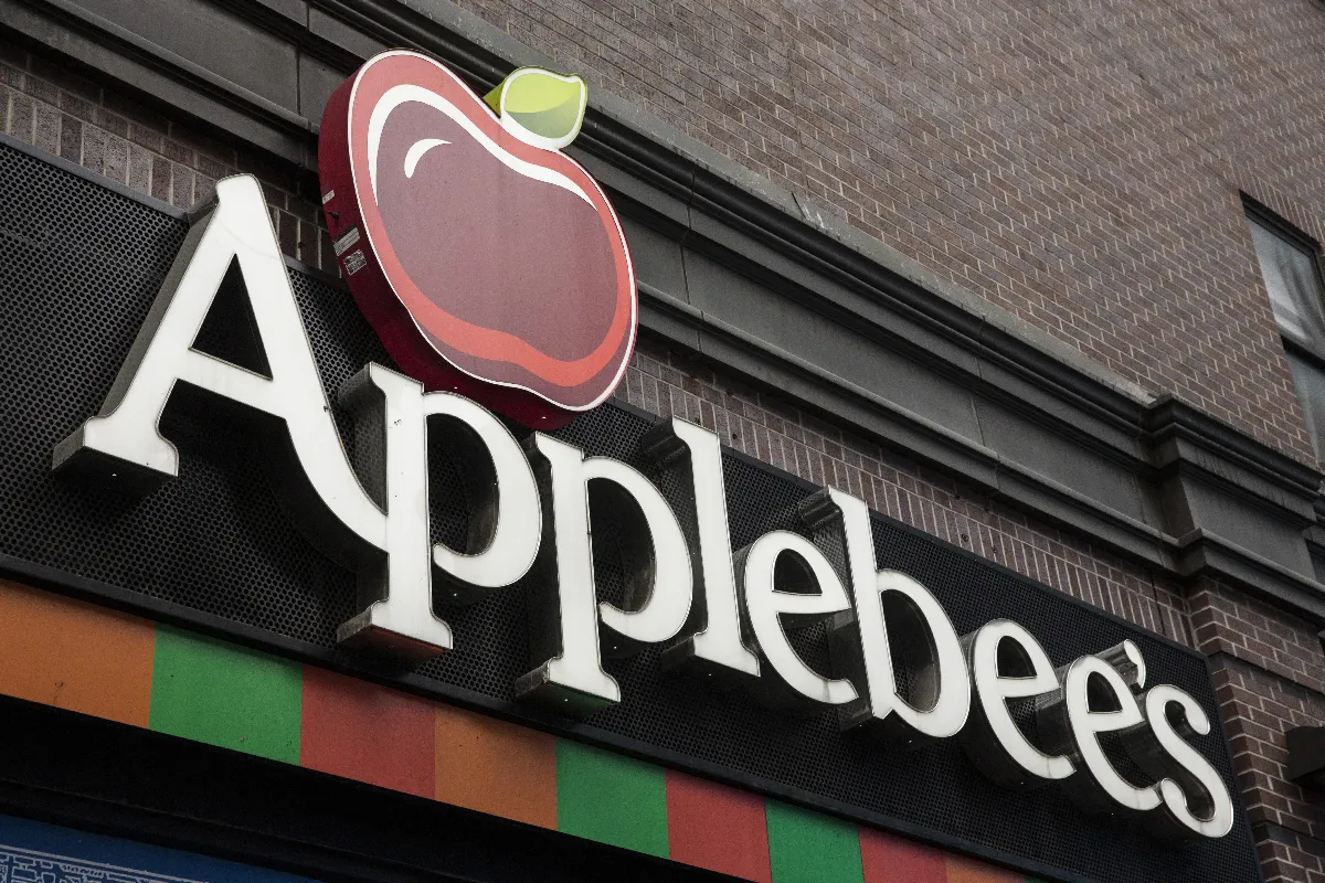 An image of a sign with a red apple and the word Applebee's