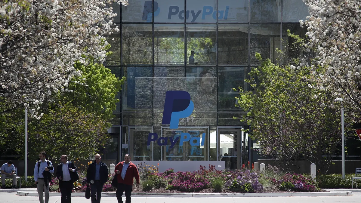 Several workers walking out of the front of PayPal offices