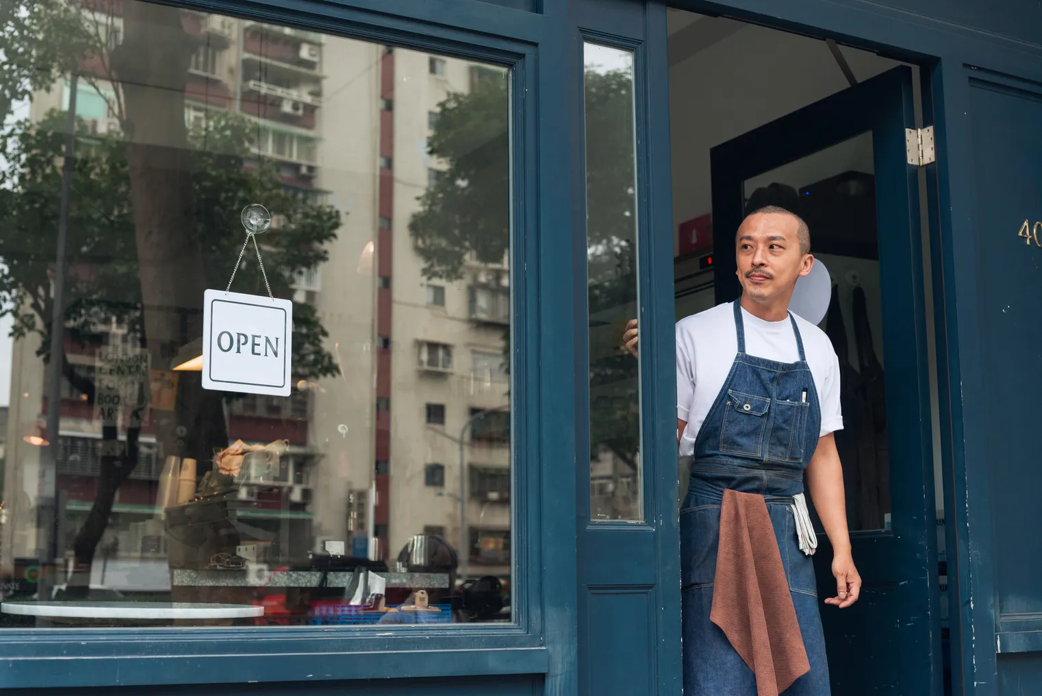 Coffee shop owner with Open sign