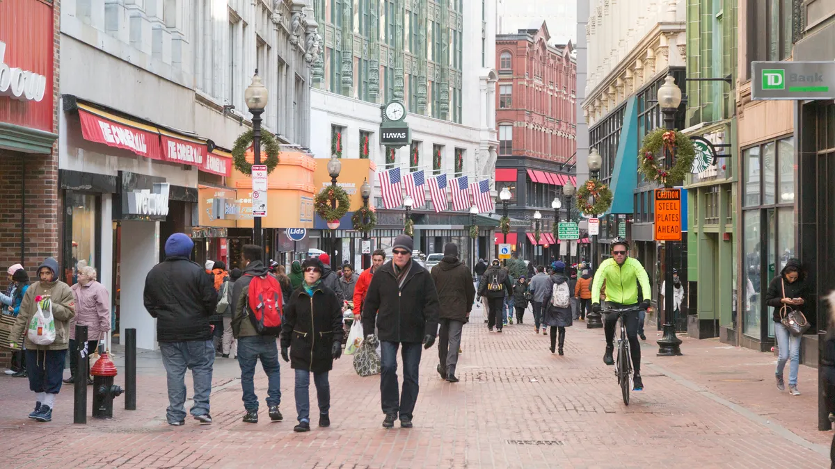 People walking and biking on a street that is closed to automobile traffic.