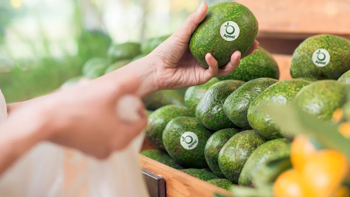 A shopper takes an Apeel avocado, treated to have a longer shelf life