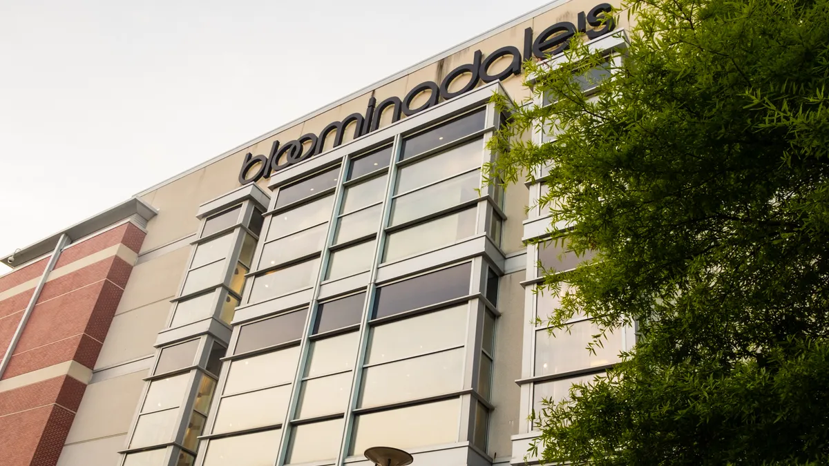 A building seen at an angle, with a leafy tree visible on the right.