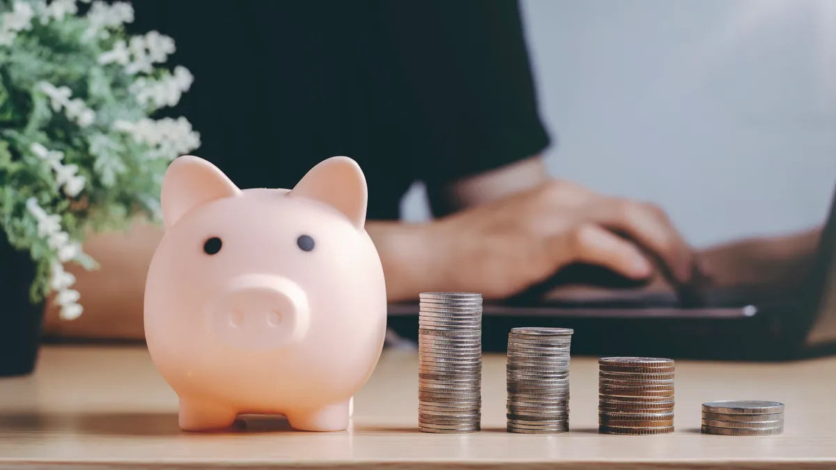 A piggy bank sits next to stack of coins to represent growing investments