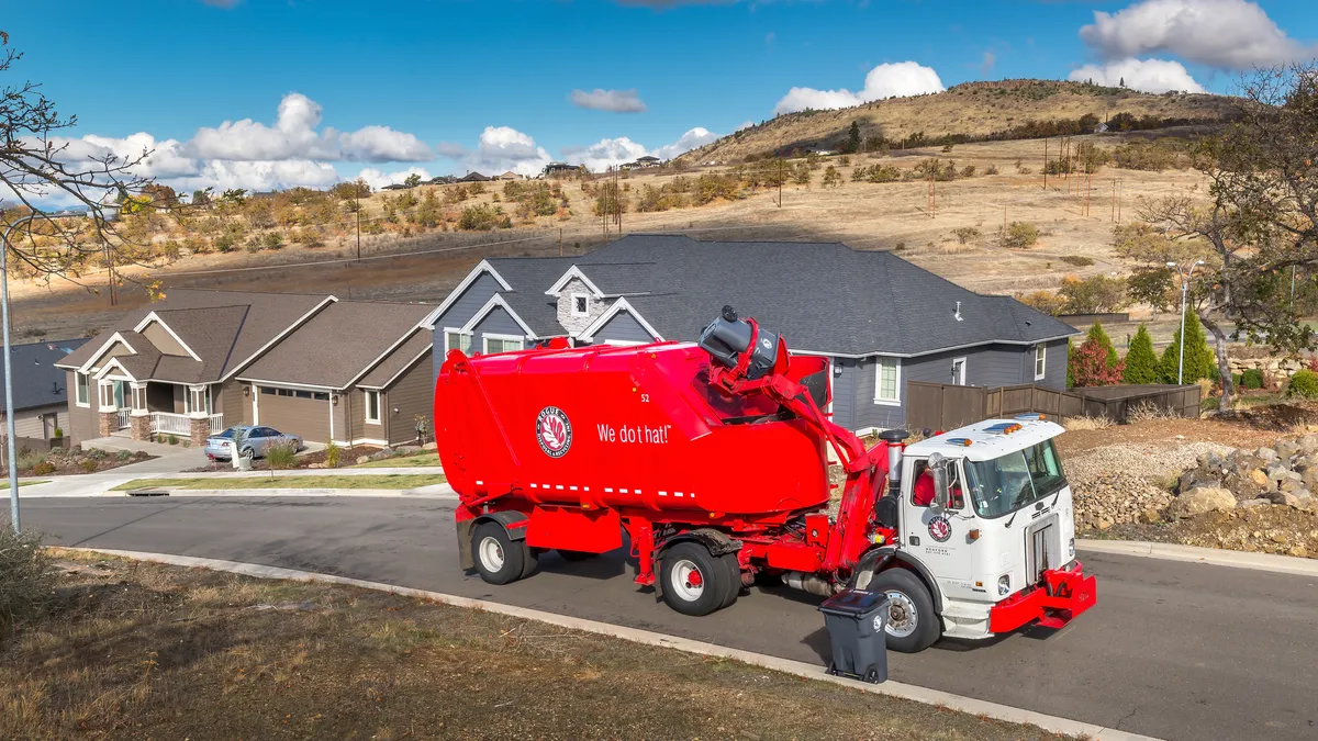 Red truck collecting waste on a rural street