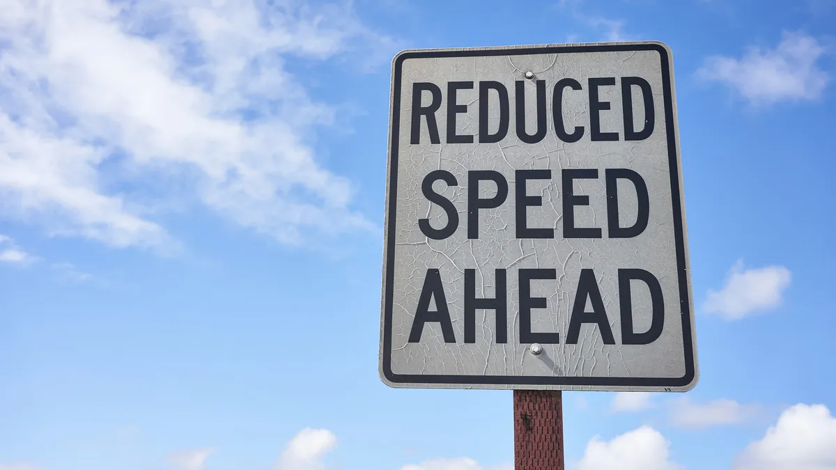 A traffic sign indicates reduced speed ahead.