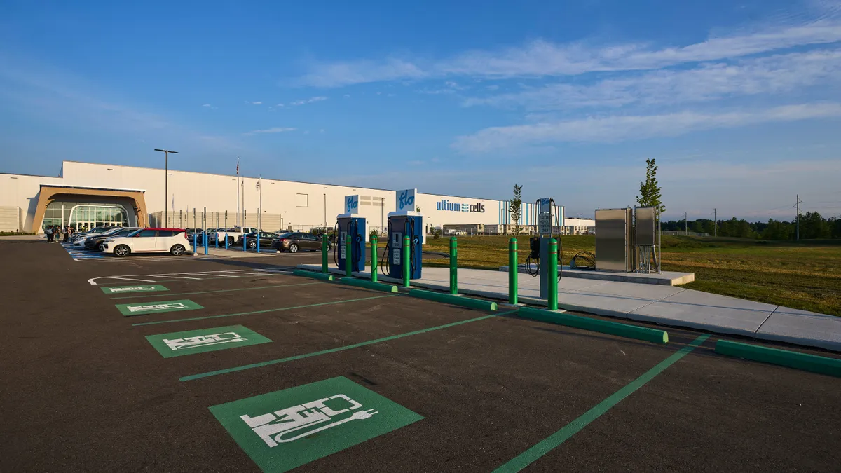 The exterior of the Ultium Cells battery cell factory in Warren, Ohio showing parking spaces equipped with electric vehicle chargers.