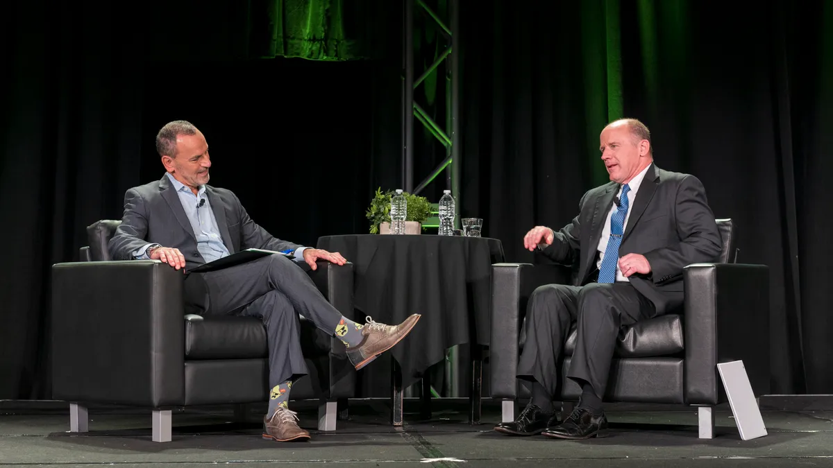 White House Port and Supply Chain Envoy Gen. Stephen Lyons speaks with Association of Supply Chain Management CEO Abe Eshkenazisit sit on black arm chairs in the middle of a conversation